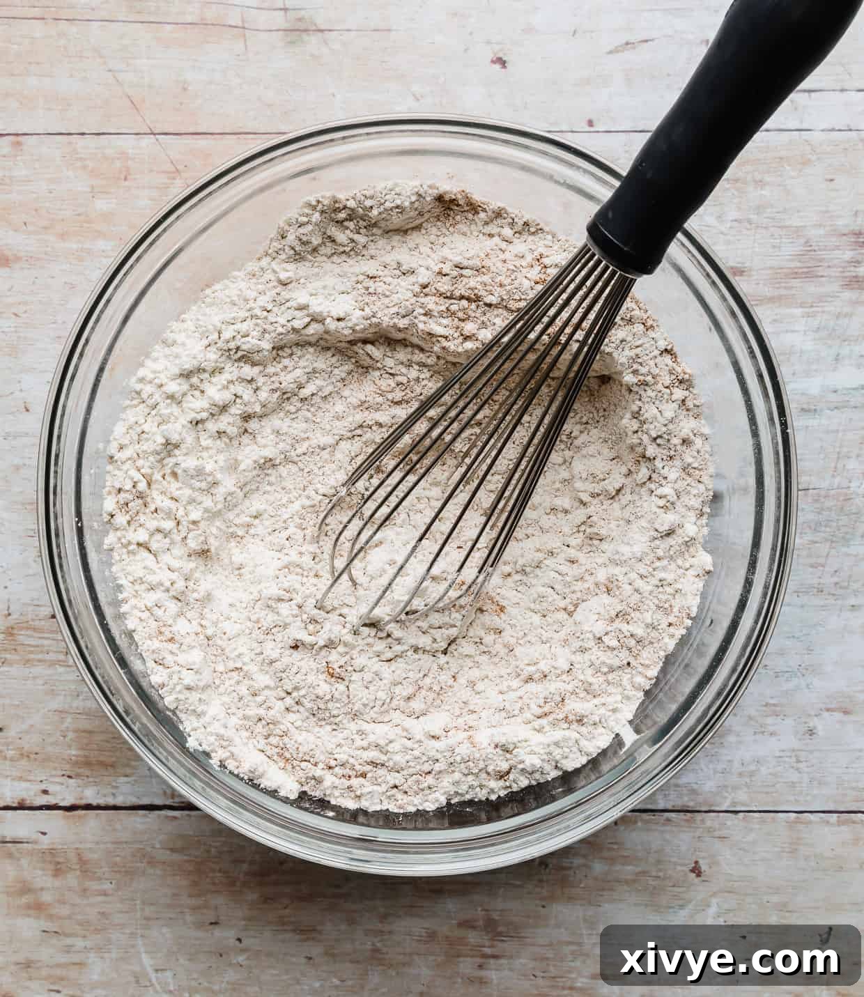A whisk stirring flour and dry ingredients.