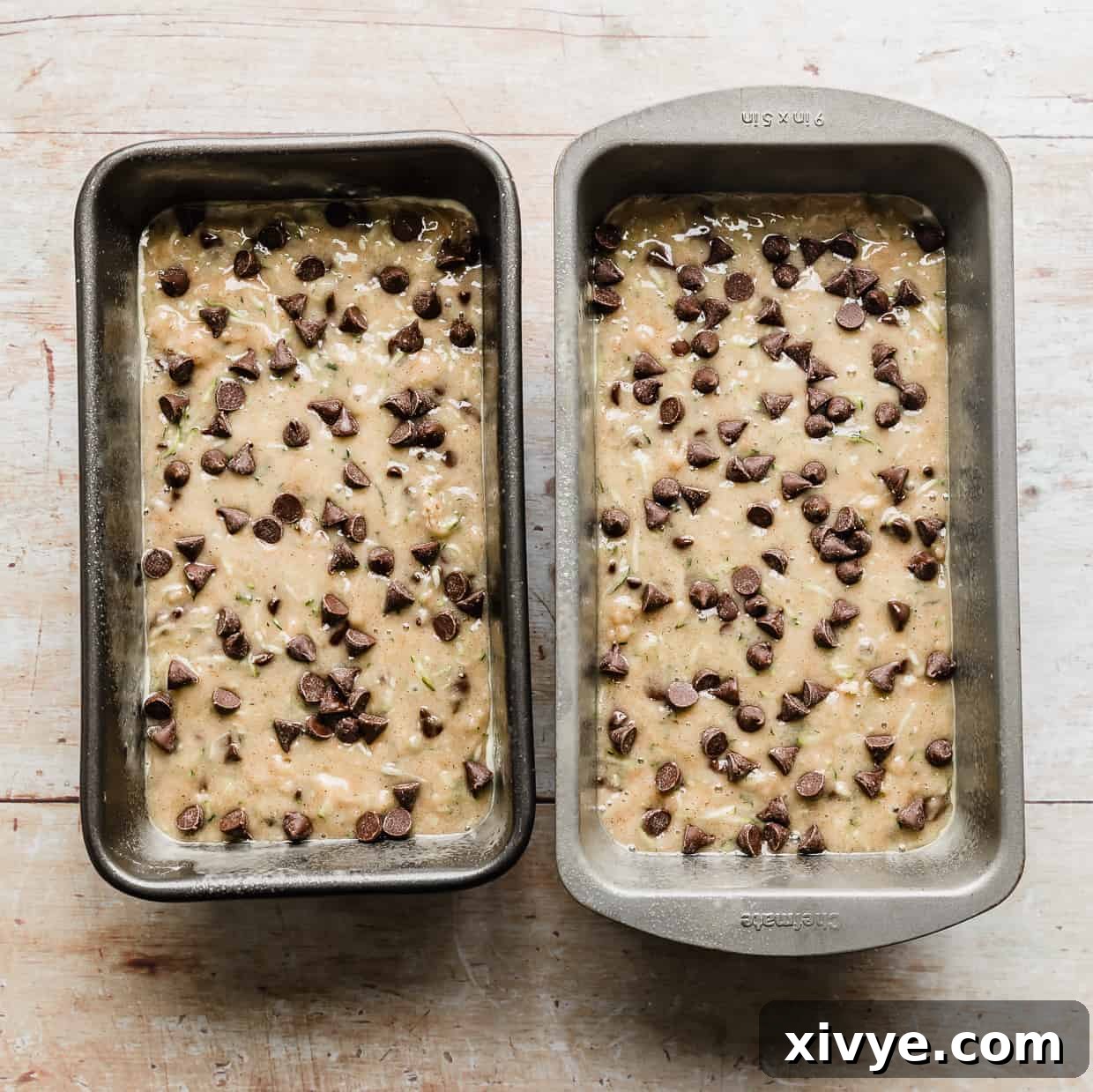 Two bread pans with Chocolate Chip Zucchini Bread batter in each.