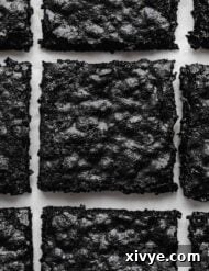 Ultimate Blackout Brownies 9 Crackly top Black Cocoa Brownies cut into squares on a white background.