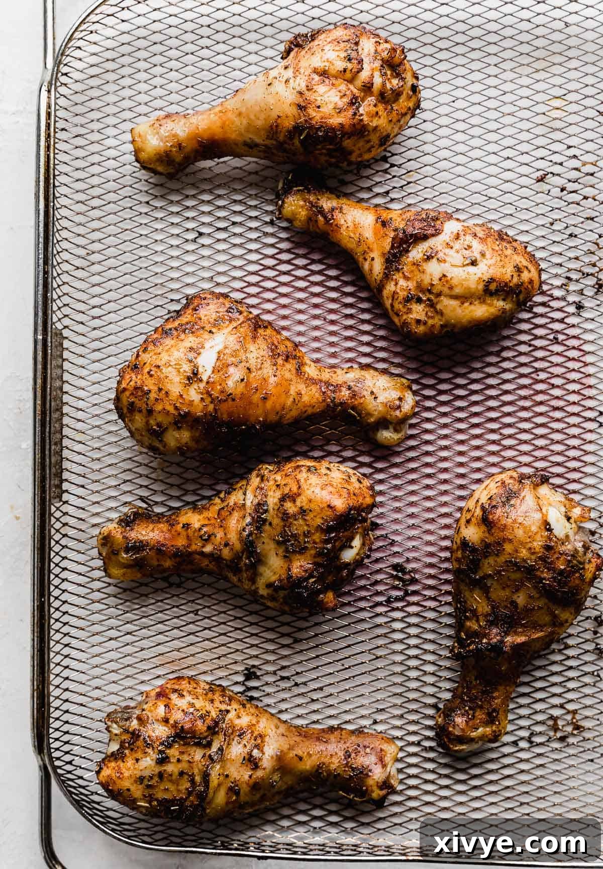 Crispy Air Fryer Drumsticks 8 Golden brown and crispy air fryer drumsticks on a wire air fryer rack.