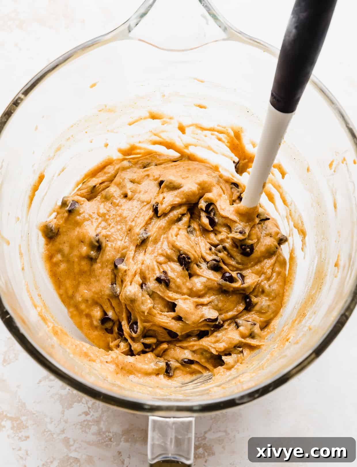 Finished Pumpkin Chocolate Chip Cookie dough batter in a glass bowl, with chocolate chips evenly folded in, ready for scooping and baking.