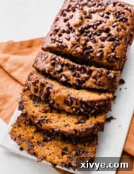Spiced Pumpkin Chocolate Chip Bread 10 A sliced Pumpkin Chocolate Chip Bread on a white plate.