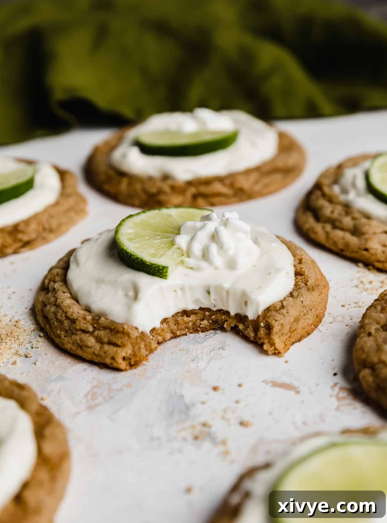 Tangy Key Lime Cookie Delight 2 A bite taken out of a copycat Crumbl Key Lime Pie Cookie on a white background.