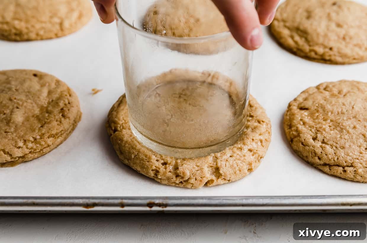 Tangy Key Lime Cookie Delight 6 A glass cup pressing into the top of a tan colored cookie.