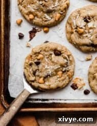 A 7 Layer Bar Cookie on a metal spatula near a burnt orange colored napkin.