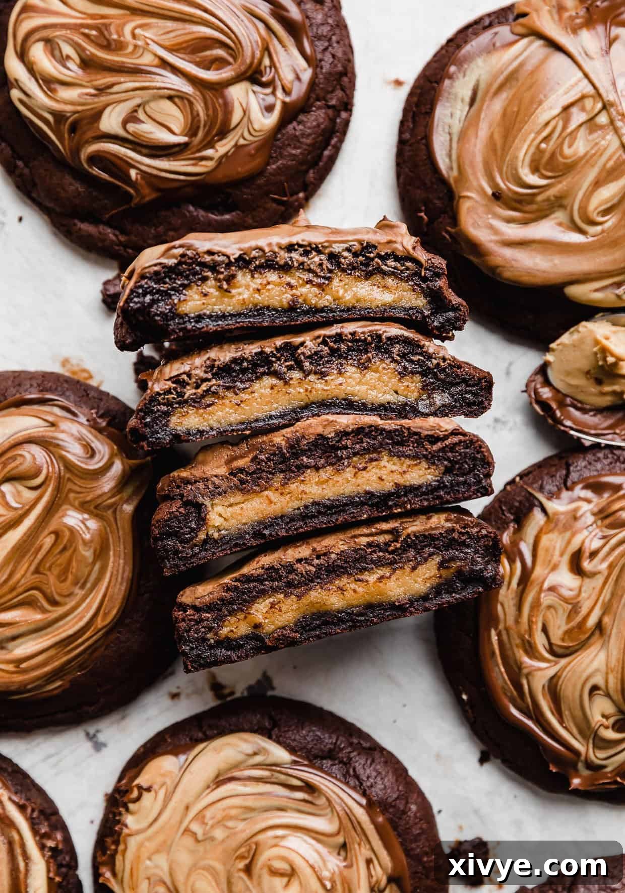 Fudgy Peanut Butter Brownie Cookies 3 Crumbl Peanut Butter Brownie Cookies cut in half showing the peanut butter cookie in the center.