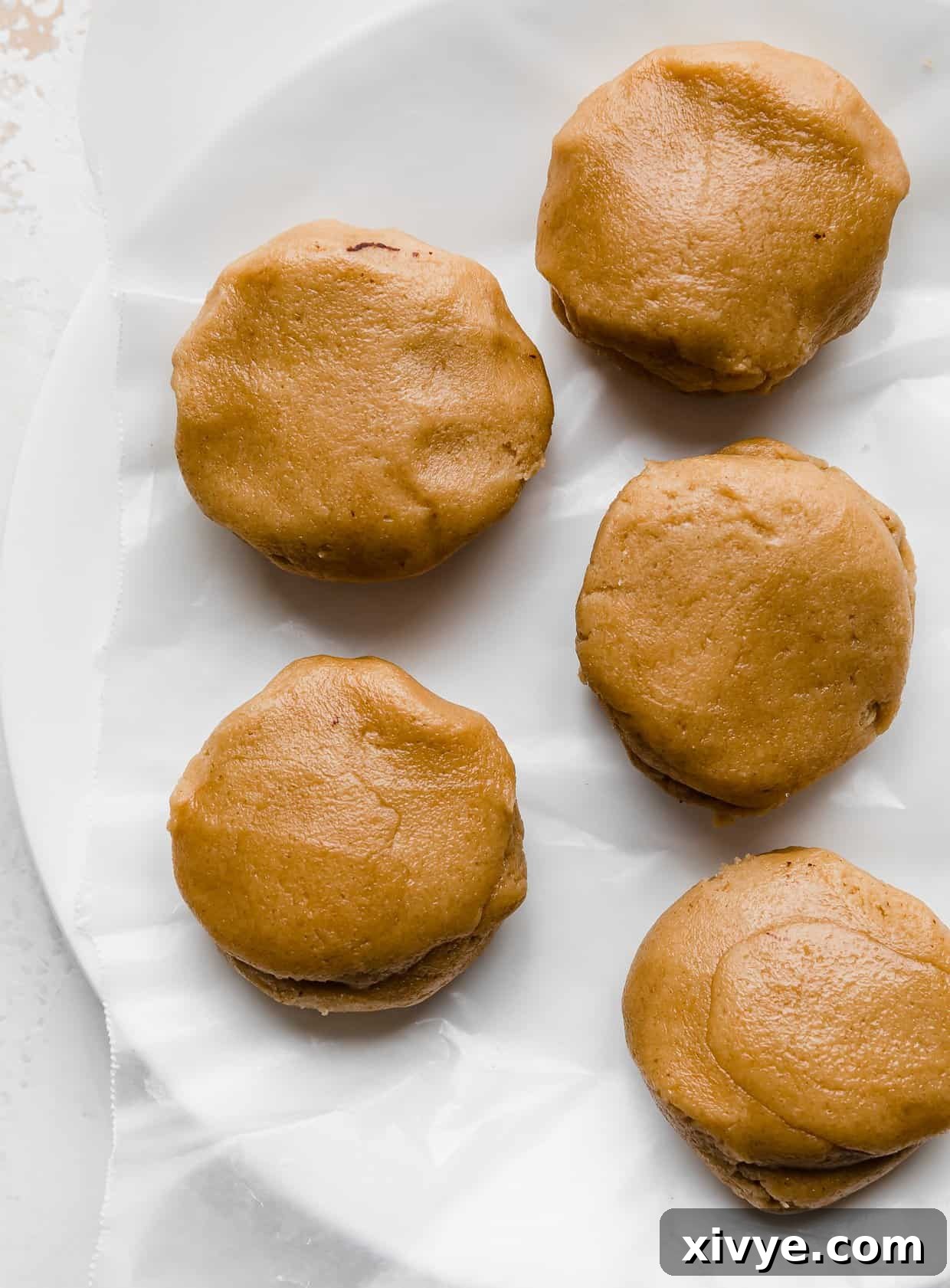 Fudgy Peanut Butter Brownie Cookies 4 Peanut butter cookie dough balls on a white plate.