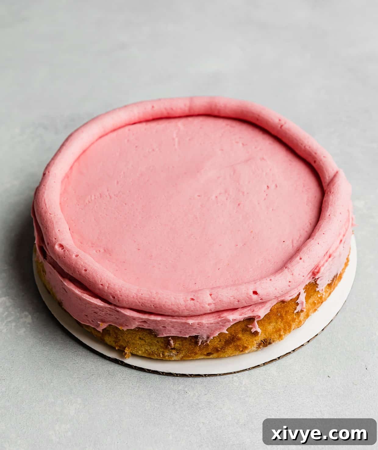 Zesty Lemon Raspberry Delight 7 A round Lemon Raspberry Cake layer with a perfect buttercream dam piped around its perimeter, ready for filling.