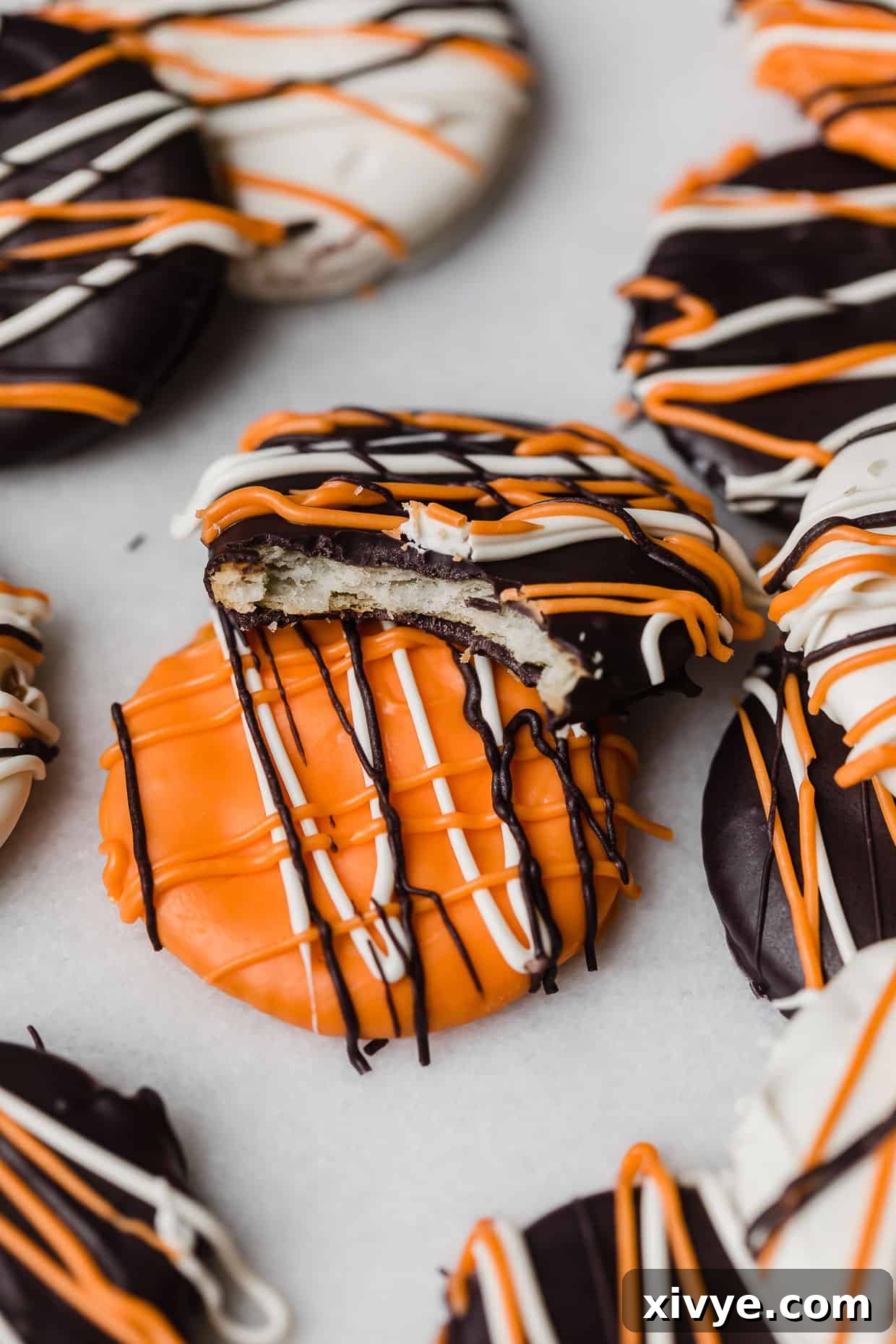 A bite taken out of a Halloween Cracker that's covered with black, orange, and white melted chocolate.