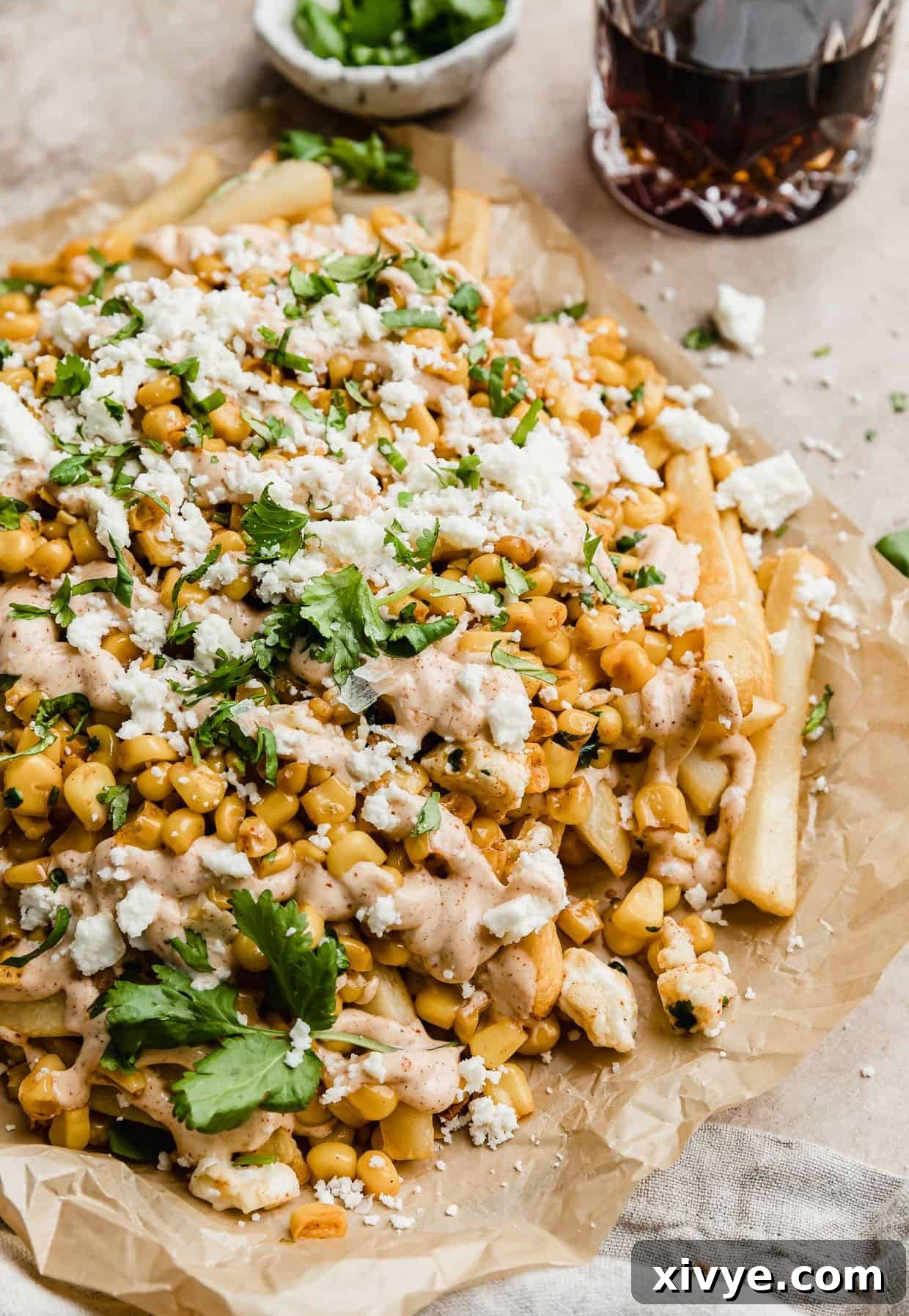 Golden Corn Sticks 2 Crispy Mexican Street Corn fries generously topped with queso fresco cheese and fresh cilantro, served on parchment paper.