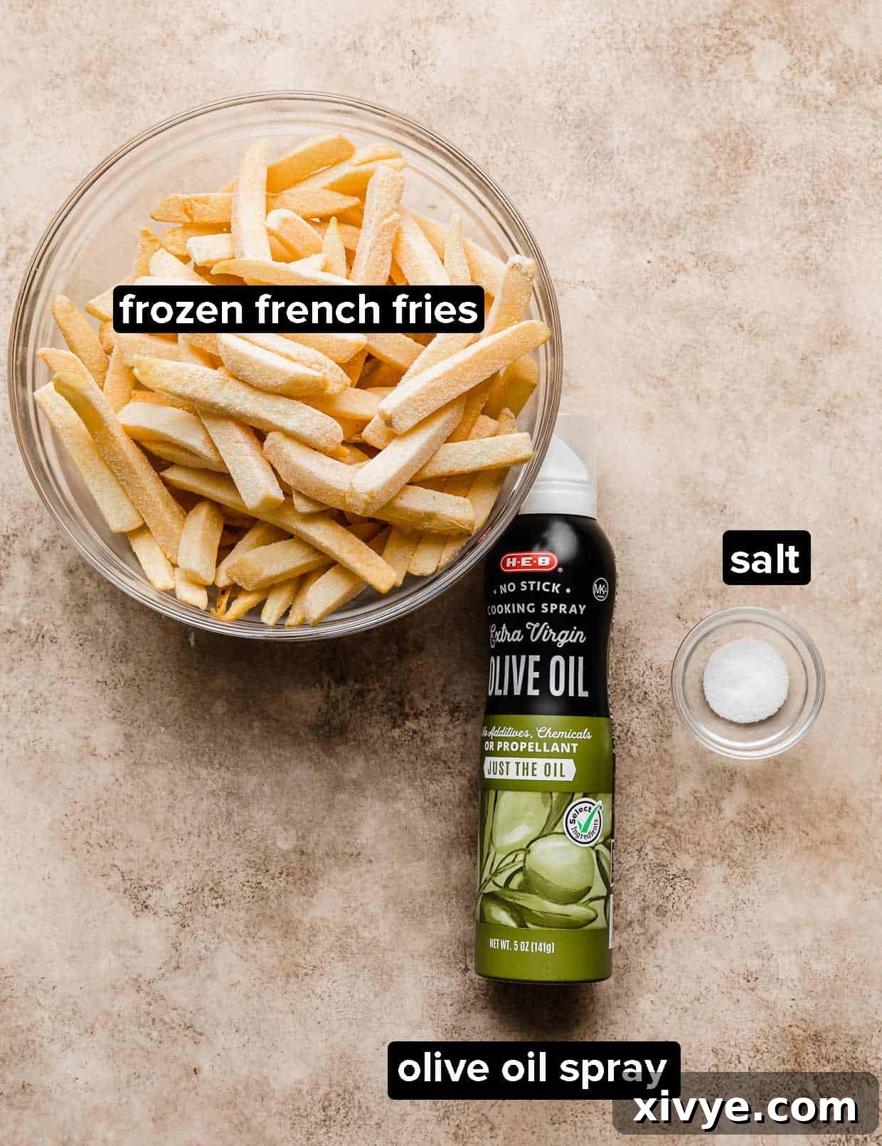 Ingredients used to make Air Fryer Frozen French Fries on a tan textured background.