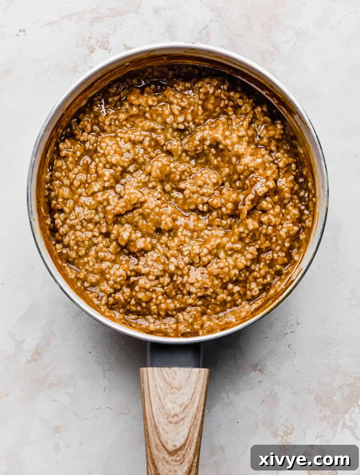 Spiced Pumpkin Steel Cut Oats 6 Pumpkin Steel Cut Oats in a white saucepan on a white background.