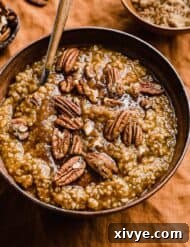 Pumpkin Steel Cut Oats in a brown bowl topped with pecans and brown sugar.