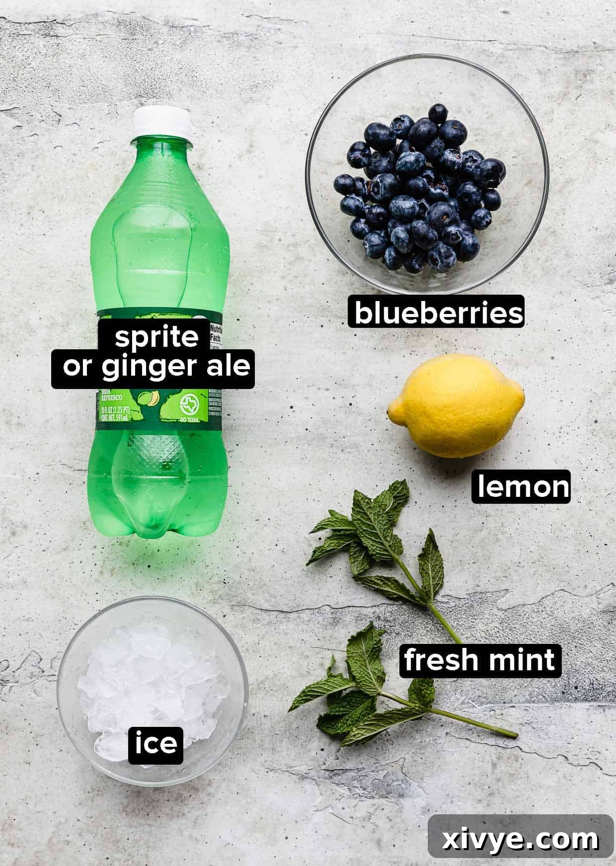 Ingredients used to make a blueberry mocktail with sprite or ginger ale, including blueberries, mint, lemons, and soda.