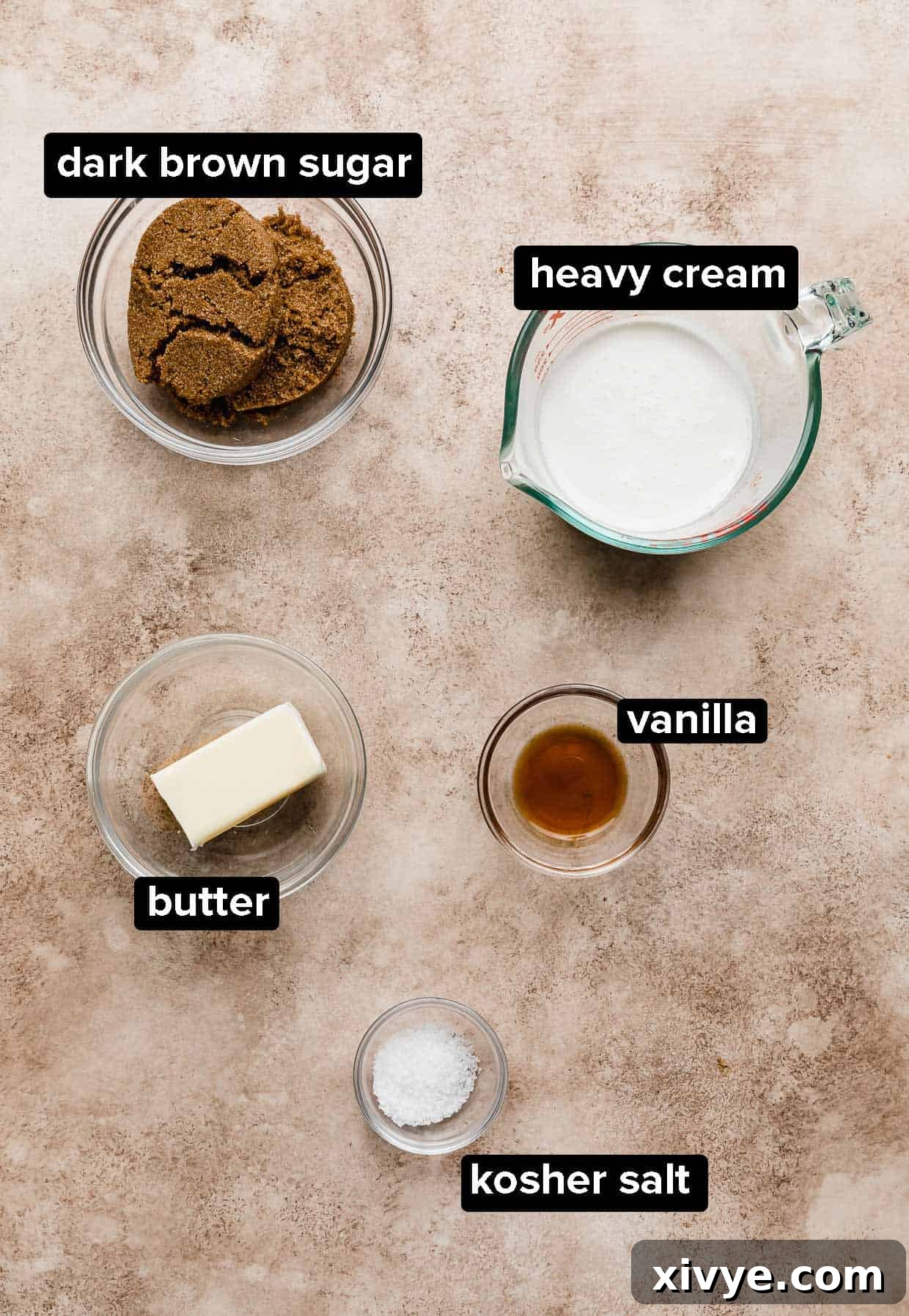 Salted Butterscotch Sauce ingredients portioned into glass bowls on a light brown background.