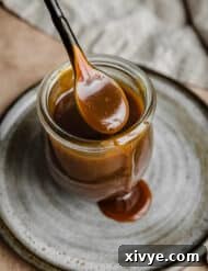 Salted Butterscotch Sauce in a jar on a gray plate.