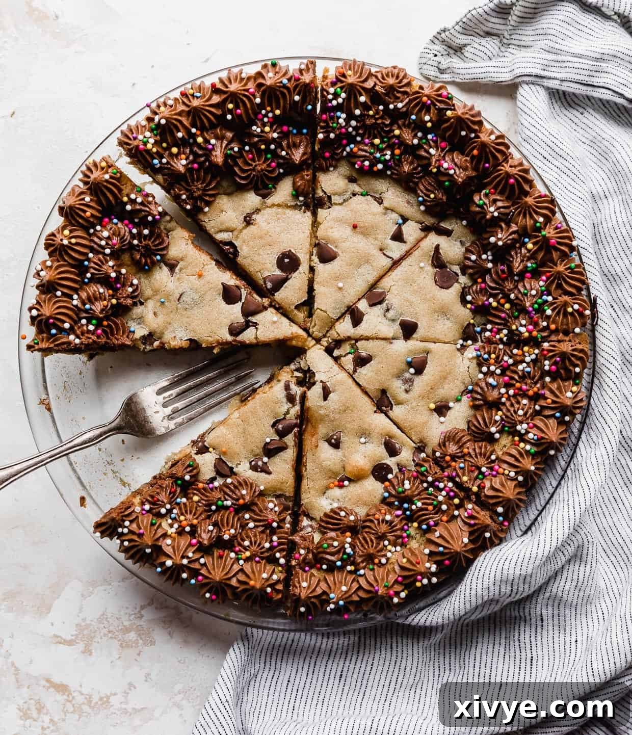 Ultimate Chocolate Chip Cookie Cake 2 A Chocolate Chip Cookie Cake Recipe made in a pie plate with the cookie cake cut into wedges.