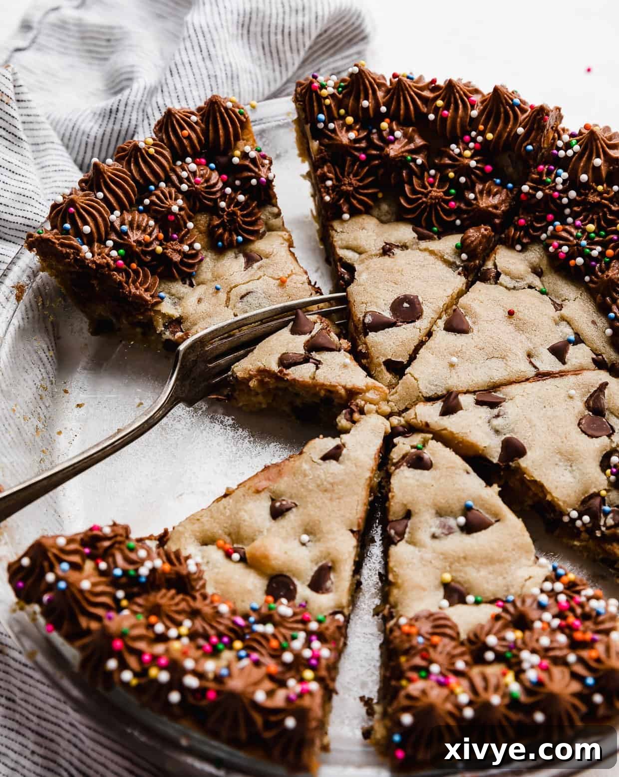 Ultimate Chocolate Chip Cookie Cake 11 A fork cutting into a wedge slice of the best Chocolate Chip Cookie Cake Recipe.
