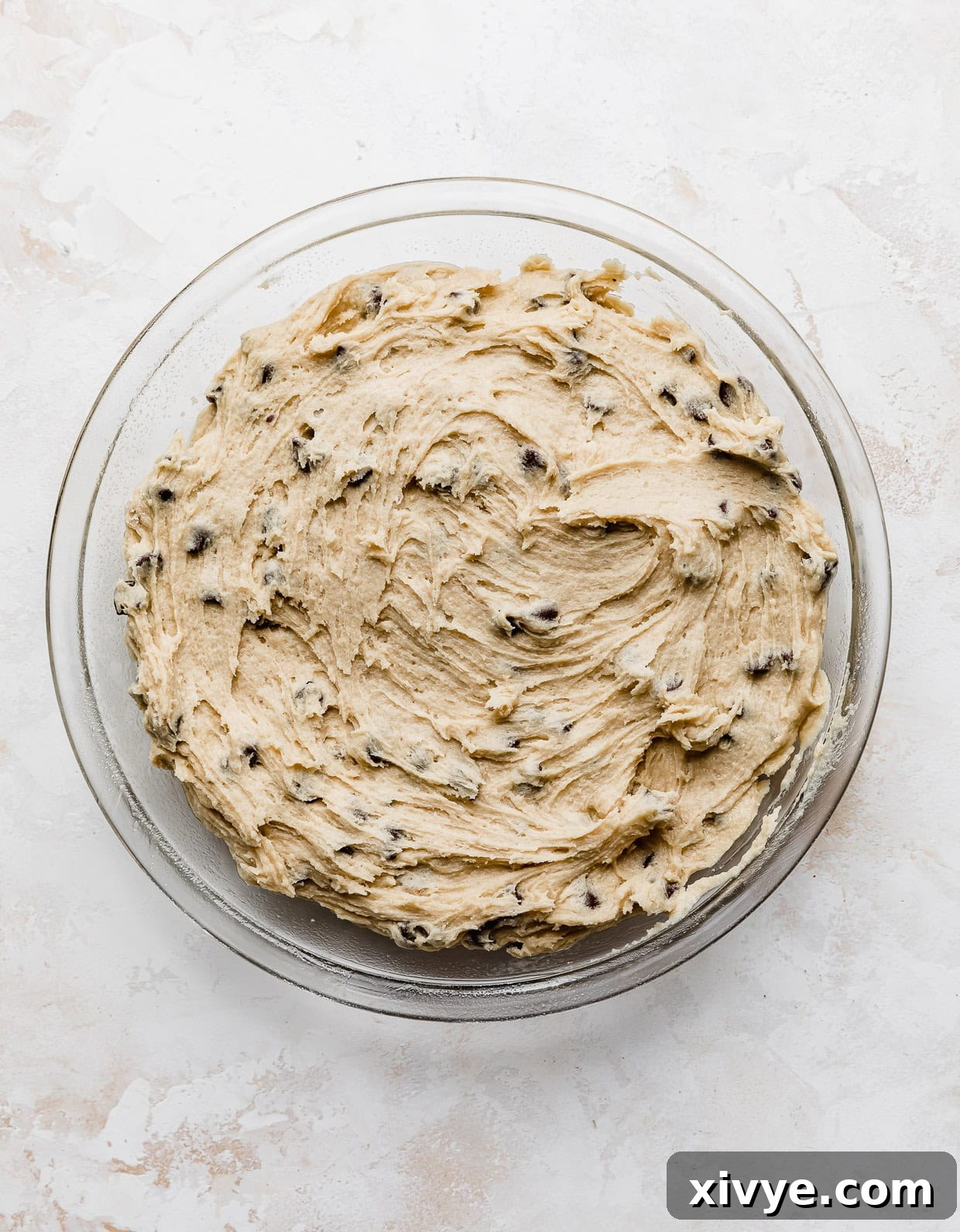 Ultimate Chocolate Chip Cookie Cake 6 Chocolate chip cookie cake cookie dough spread into a circular pie plate.