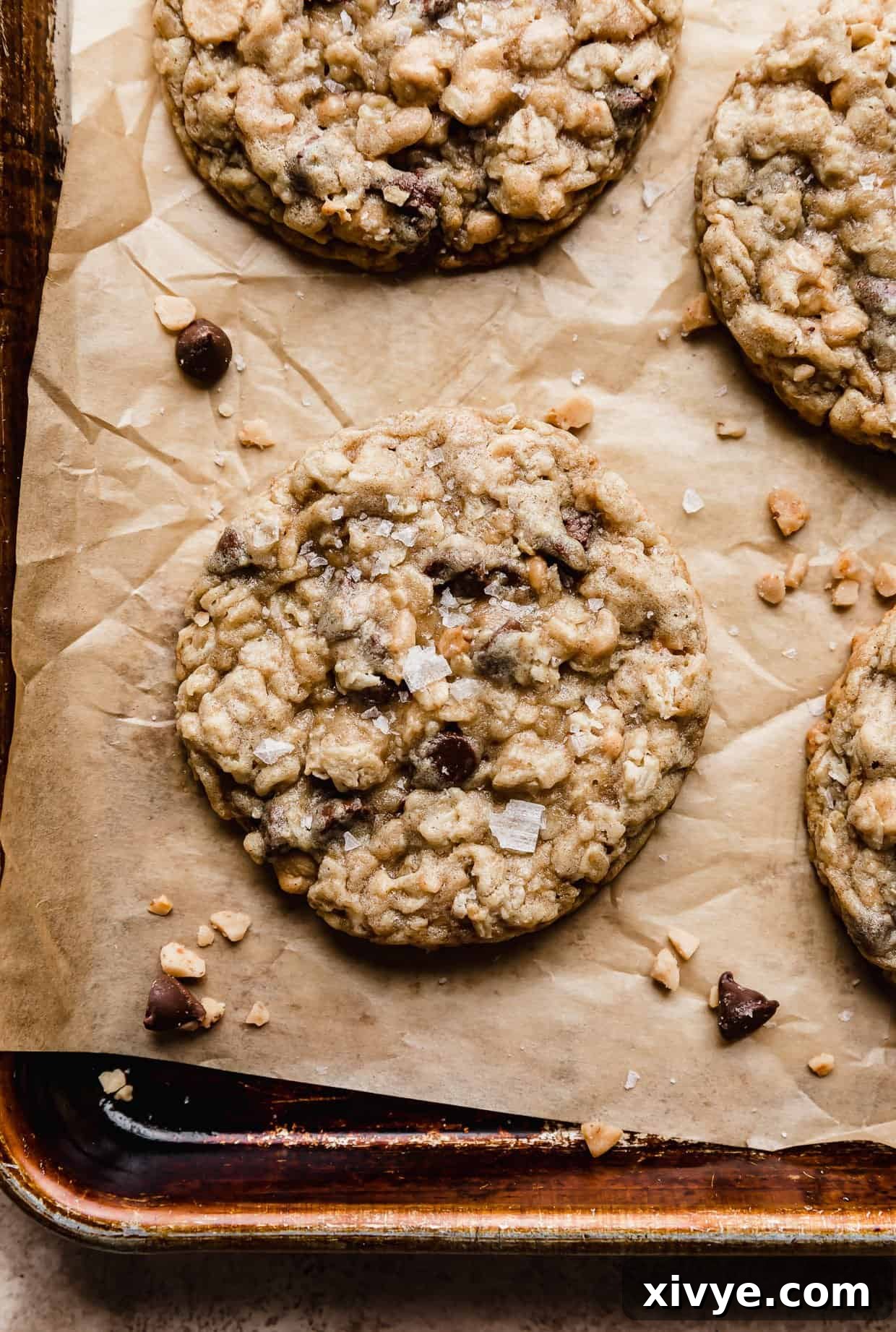 Flaky sea salt on top of a oatmeal chocolate chip peanut butter chip and toffee filled cookie.