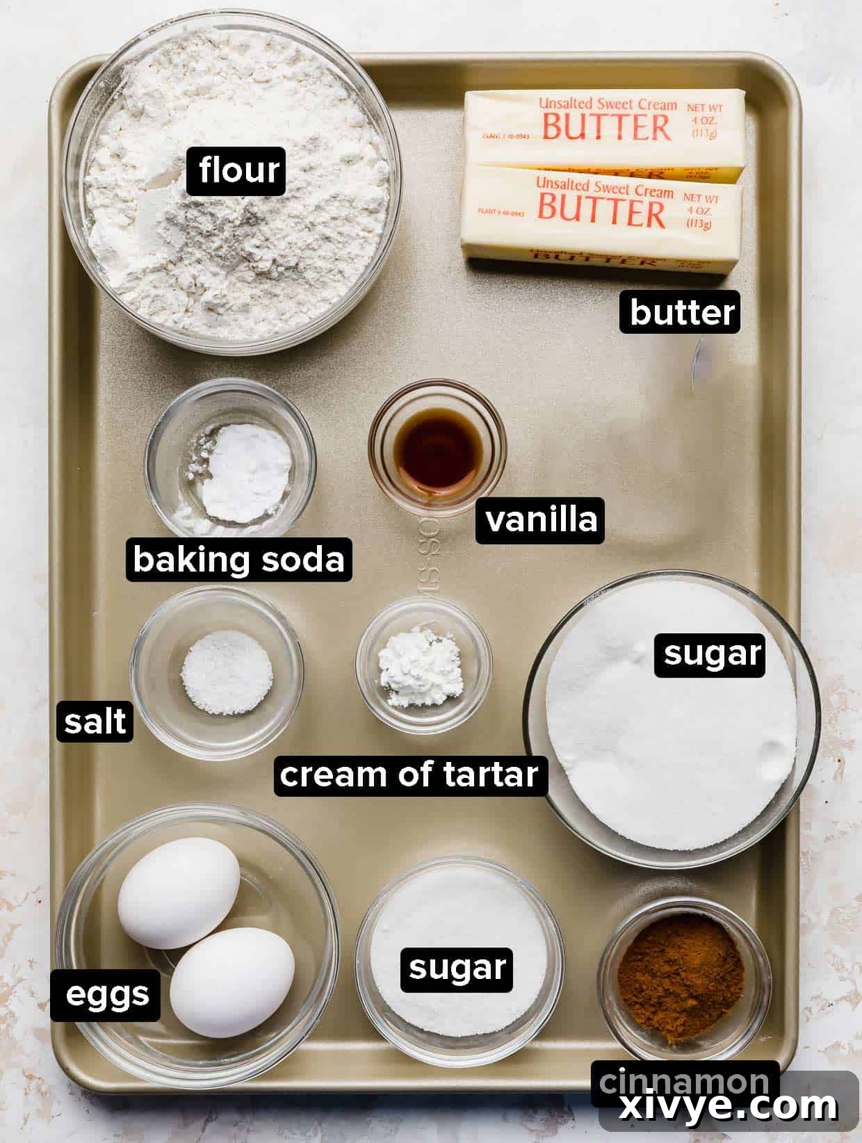 Your Ultimate Crumbl Snickerdoodle Copycat Recipe 3 Snickerdoodle Cookie ingredients on a bronze baking sheet.