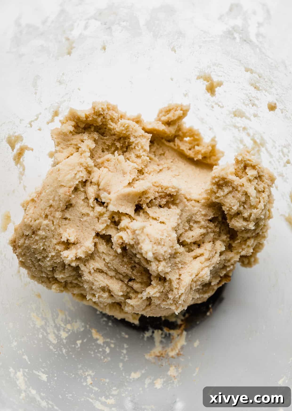 Your Ultimate Crumbl Snickerdoodle Copycat Recipe 4 Snickerdoodle Crumbl cookie dough in a glass bowl.