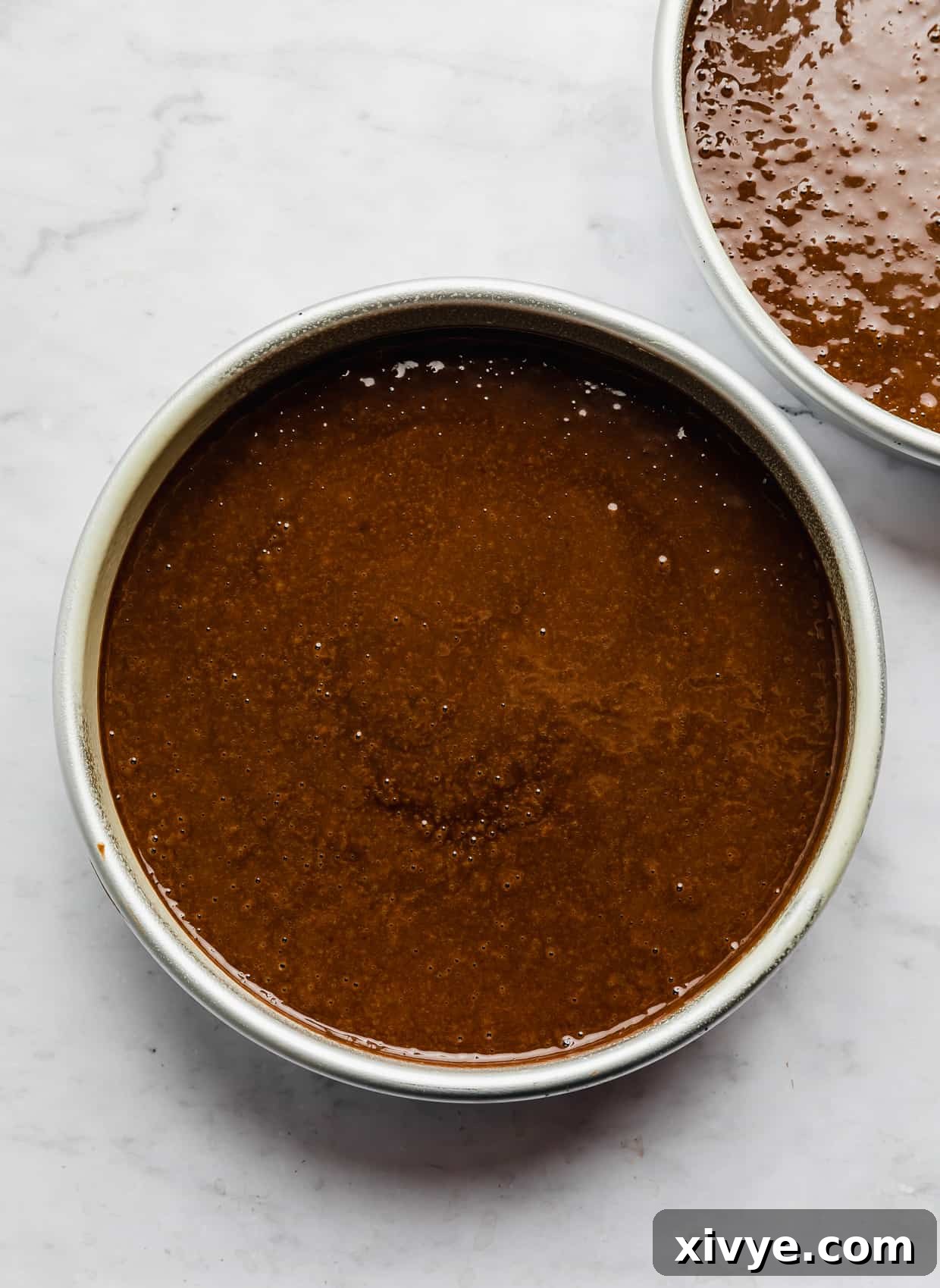 Spellbinding Harry Potter Birthday Delight 5 Chocolate cake batter in a round cake pan on a white marble background.