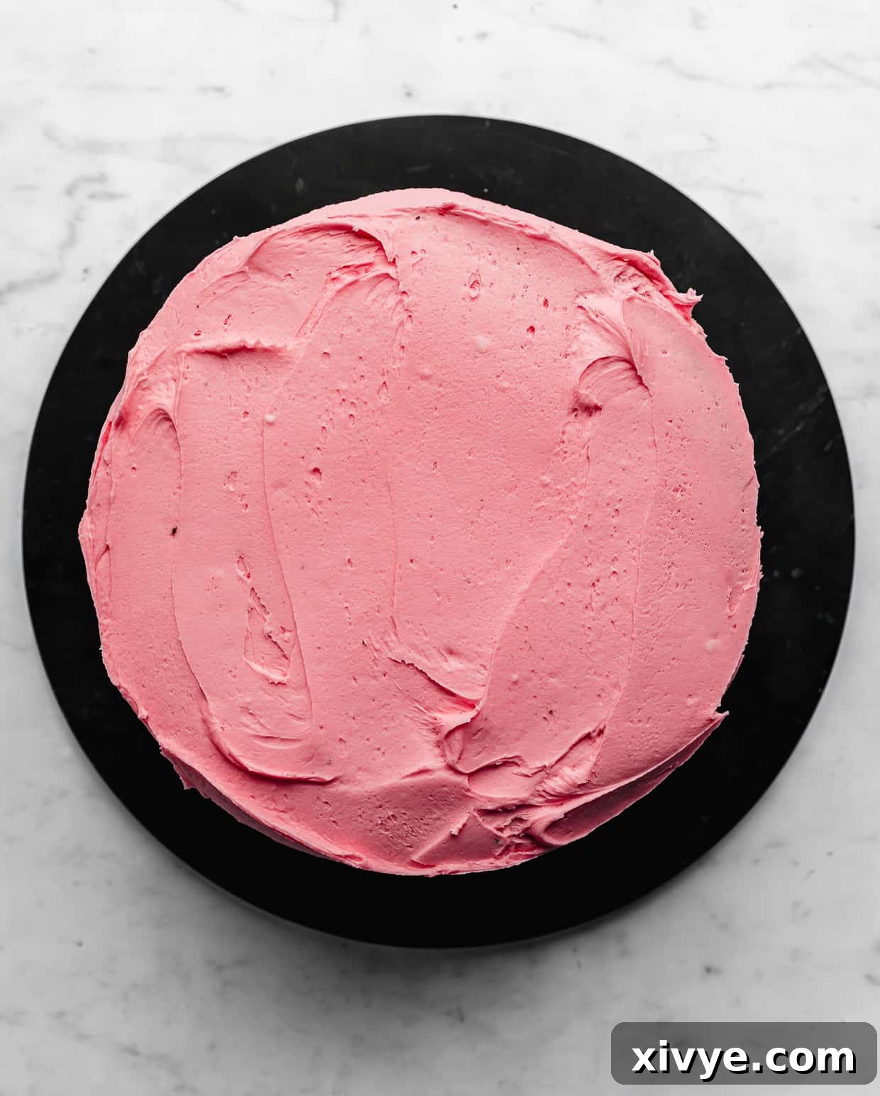 Spellbinding Harry Potter Birthday Delight 9 Overhead photo of a round cake frosted in pink frosting.