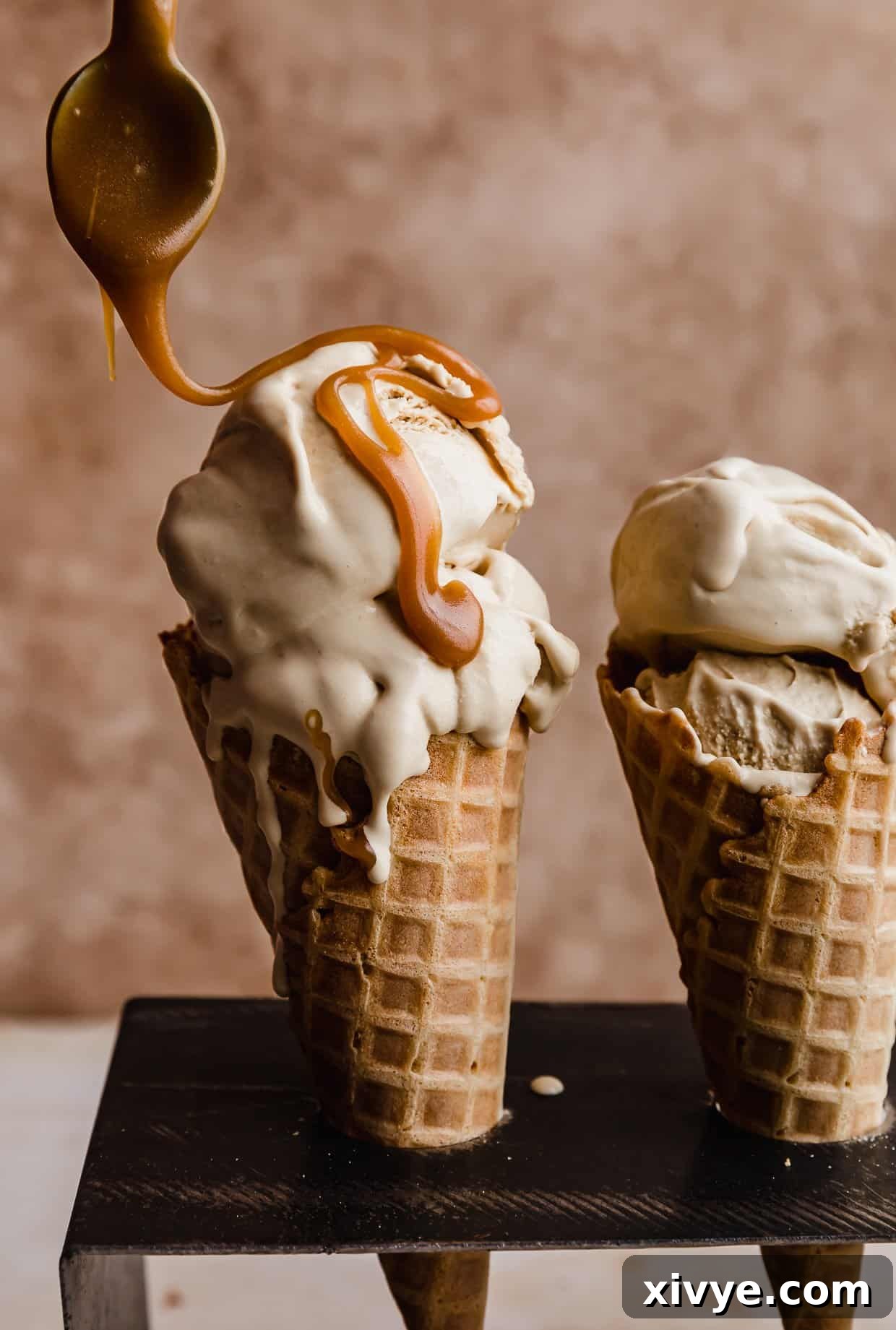 Velvet Butterscotch Indulgence 2 Butterscotch sauce being drizzled overtop Butterscotch Ice Cream that's in a waffle cone.