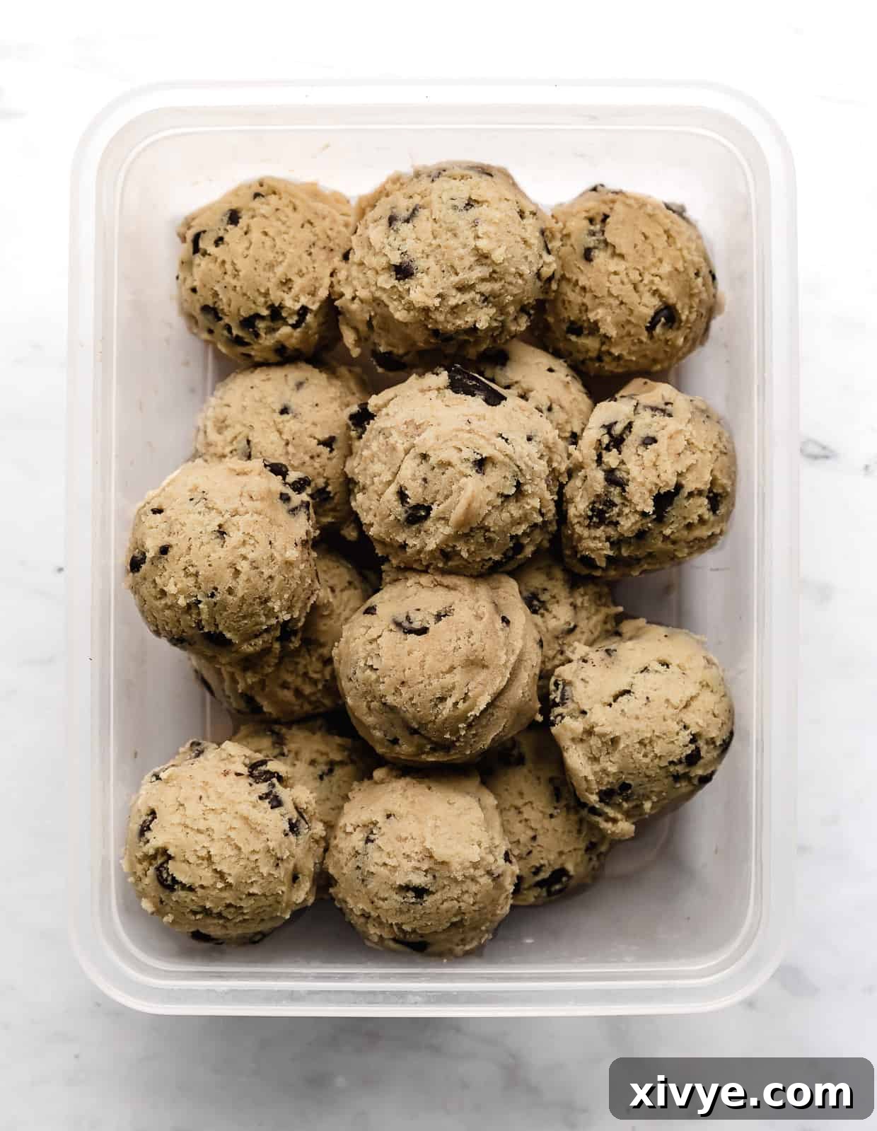 Bake Later: Freeze Cookie Dough for Future Treats 5 A pristine white background showcasing an unbaked cookie dough disk, neatly wrapped in plastic, ready for freezing or chilling.