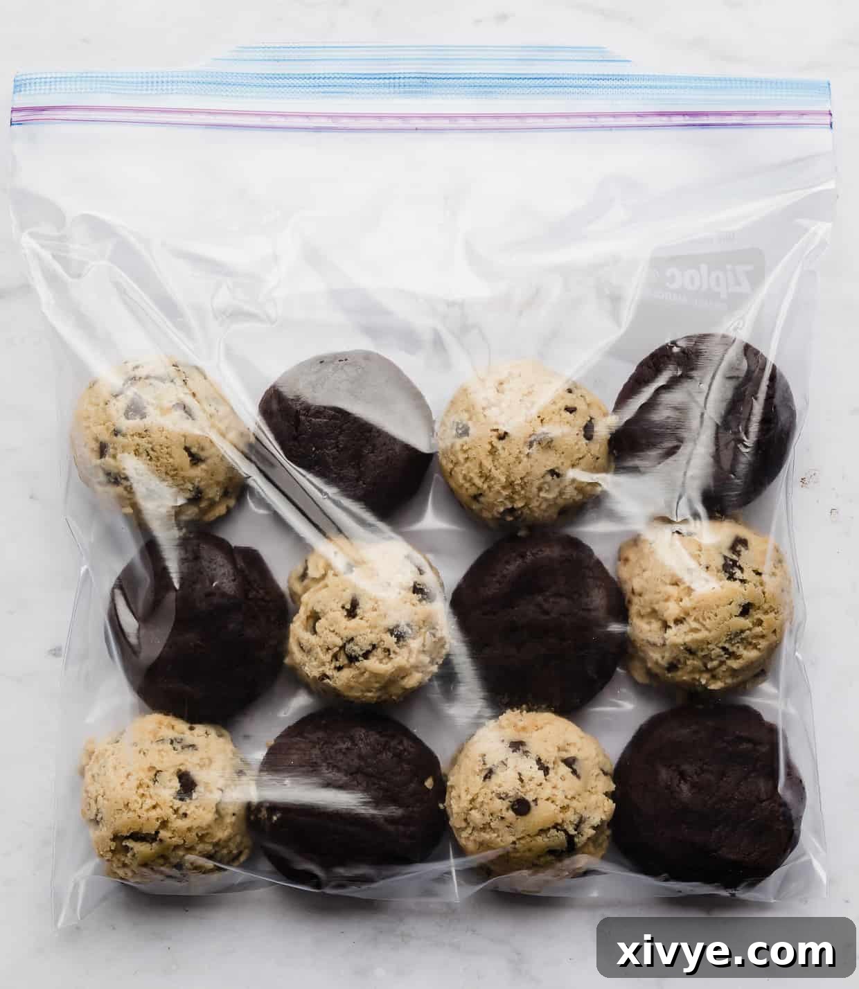 Bake Later: Freeze Cookie Dough for Future Treats 6 A clear Ziploc bag filled with an assortment of frozen cookie dough balls, including classic chocolate chip and rich brownie batter, ready for the freezer.
