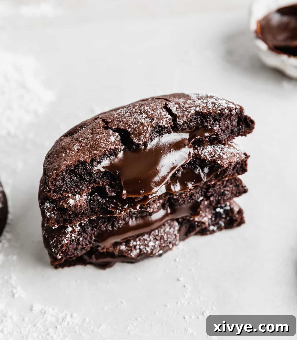 Copycat Crumbl molten lava cookies expertly cut in half, showcasing their irresistible, gooey hot fudge centers.