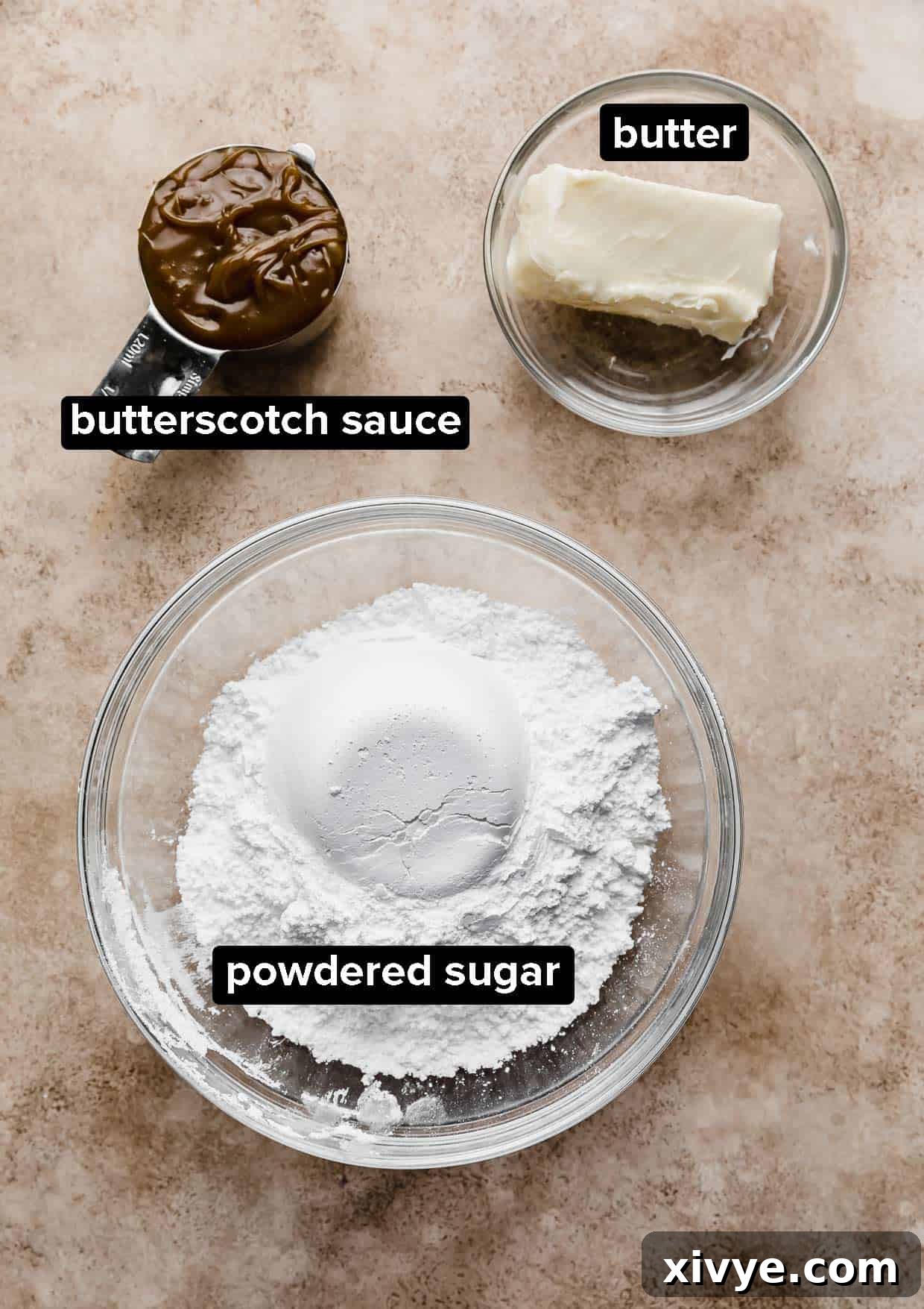 A bowl of powdered sugar, butter, and butterscotch sauce on a light brown background.