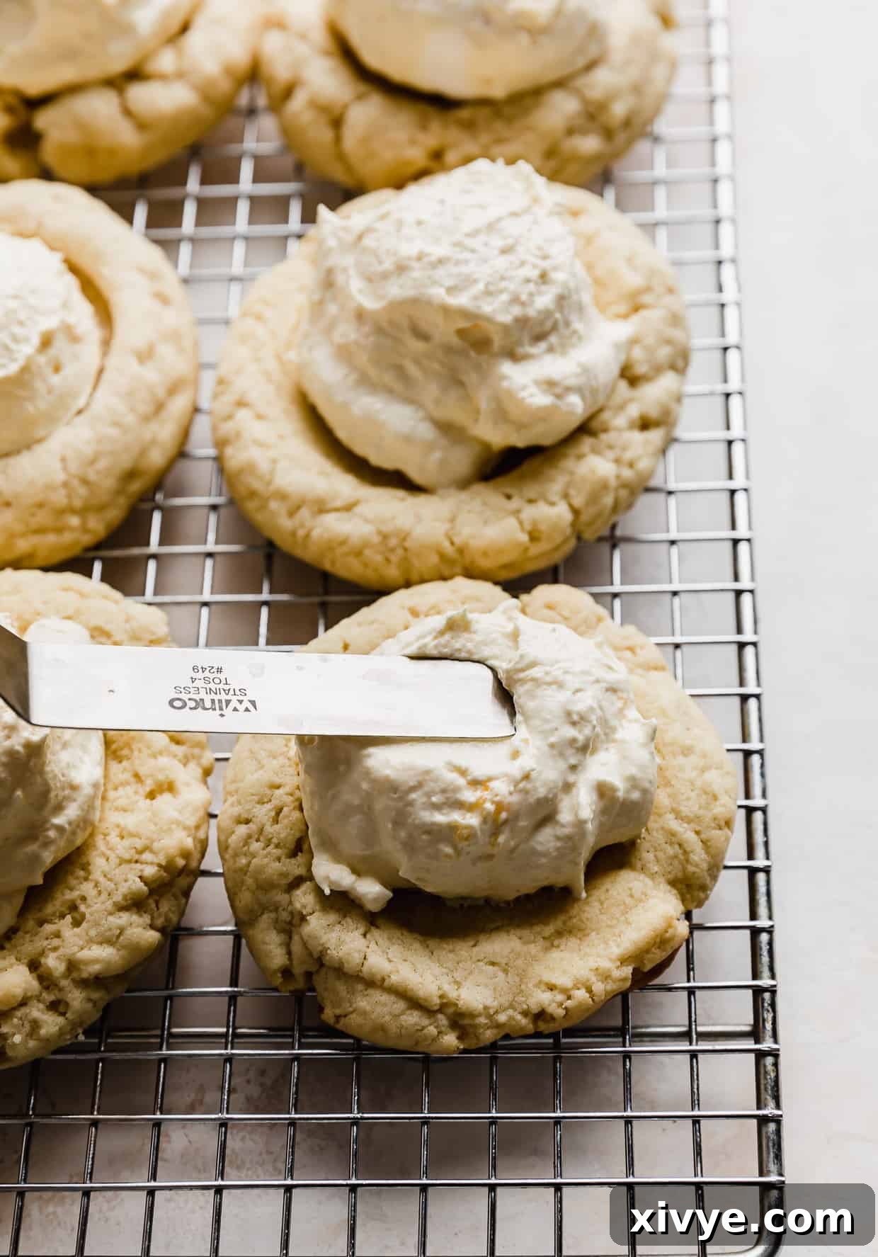 An offset spatula smoothly spreading cheat's pastry cream on a cookie.