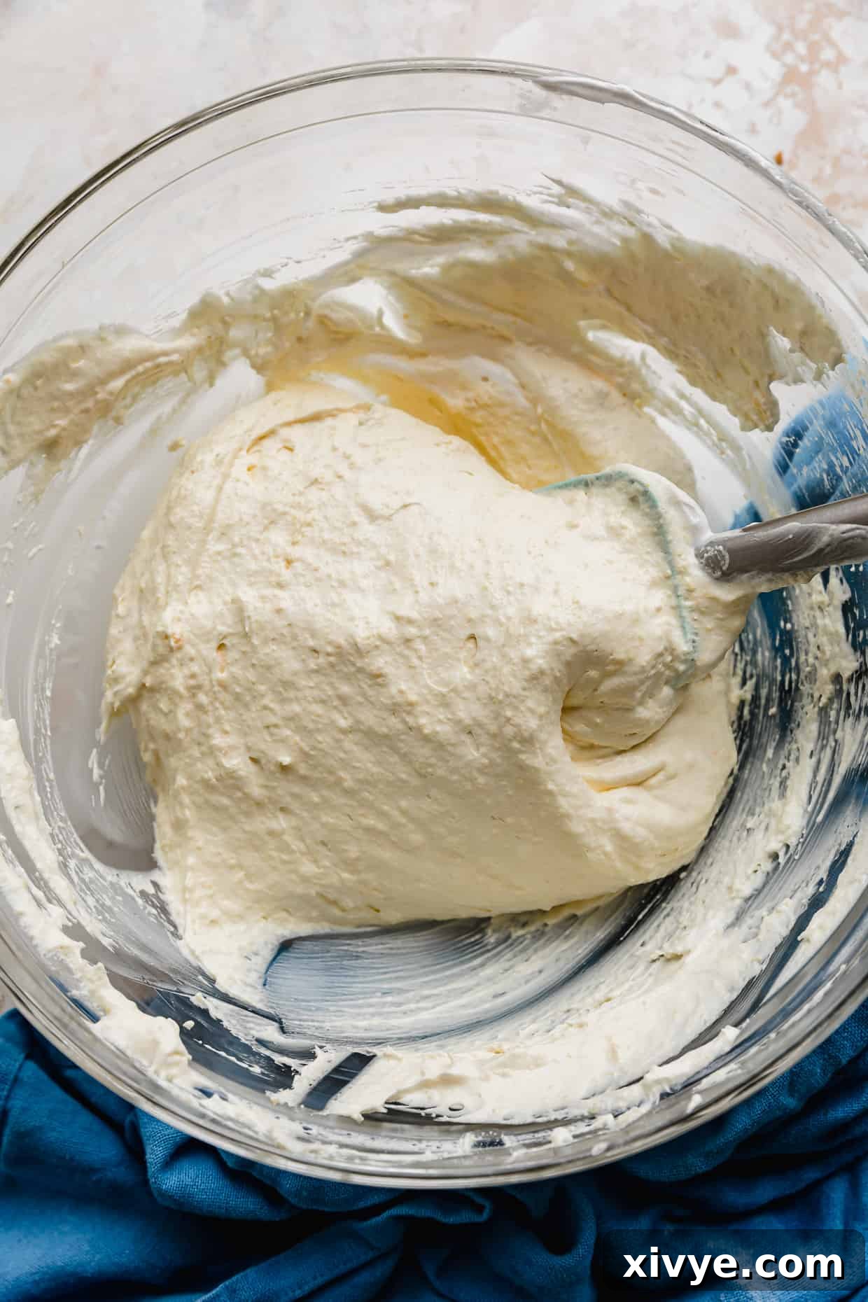 A glass bowl filled with thick vanilla pudding mixture, ready for the Cool Whip.