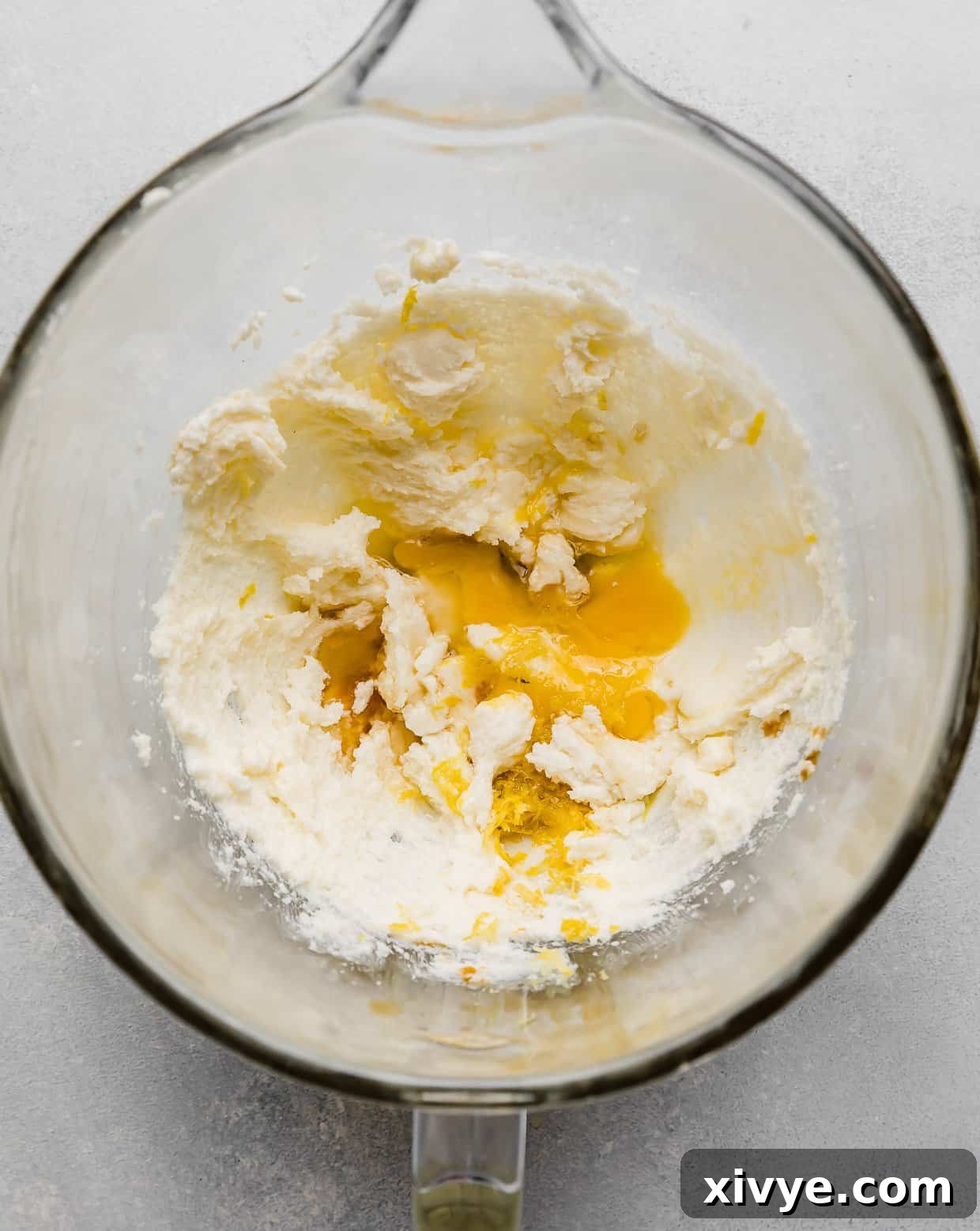Zesty Lemon Crinkles 4 Creamed butter and sugar with egg and lemon zest in a glass bowl, showcasing the vibrant lemon additions.