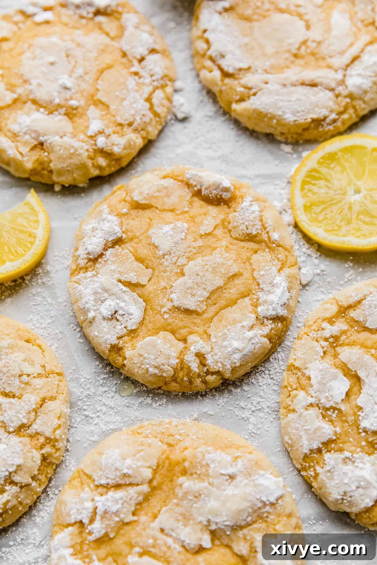 Zesty Lemon Crinkles 10 Copycat Crumbl Lemon Crinkle Cookies on a white background, highlighting their bright yellow interior and perfect dusting of powdered sugar.
