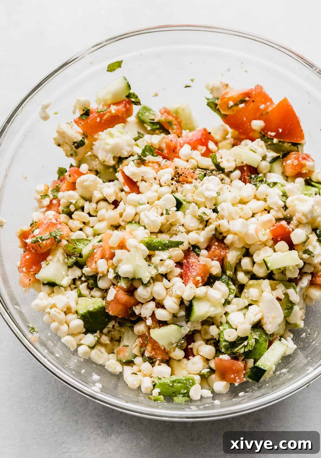 Feta Corn Salad in a glass bowl against a white background.
