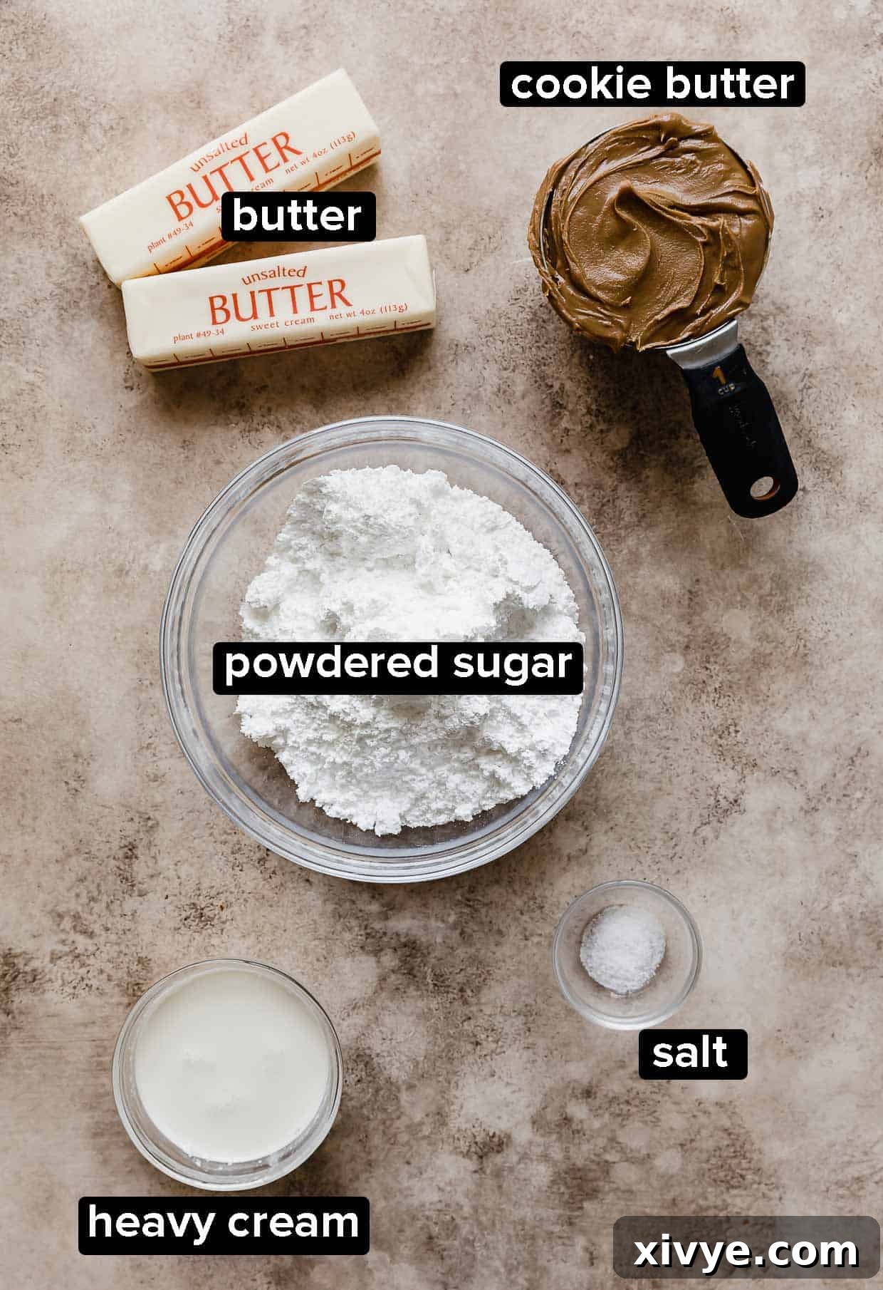 Ingredients used to make Biscoff Buttercream on a tan textured background.