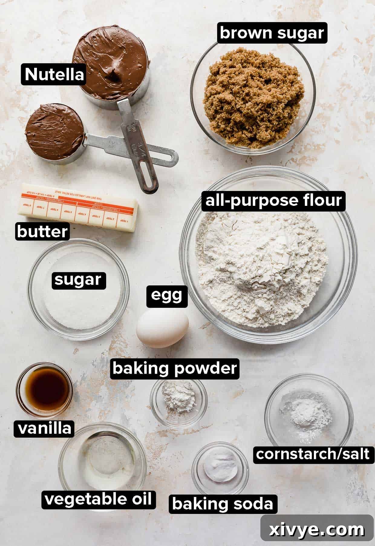 Nutella Cookies ingredients portioned into glass bowls on a white background, neatly arranged for baking.