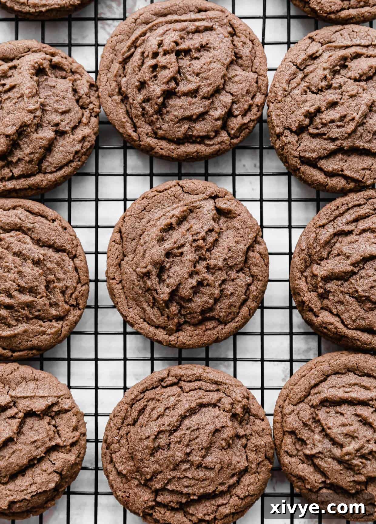 Nutella Cookies arranged neatly on a black wire cooling rack, showcasing the enticing Nutella drizzle.