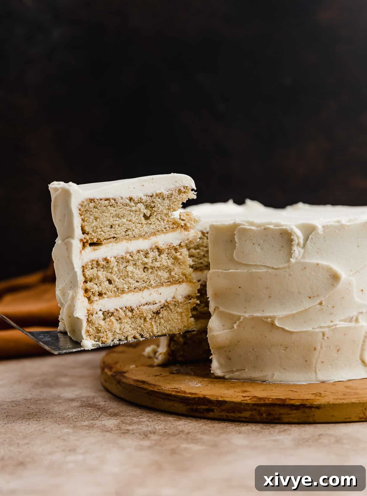 Toasted Butter Dream Cake 2 A three layered Brown Butter Cake with a slice of cake cut and balancing on a knife.
