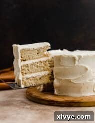 Toasted Butter Dream Cake 11 A three layered Brown Butter Cake with a slice of cake cut and balancing on a knife.