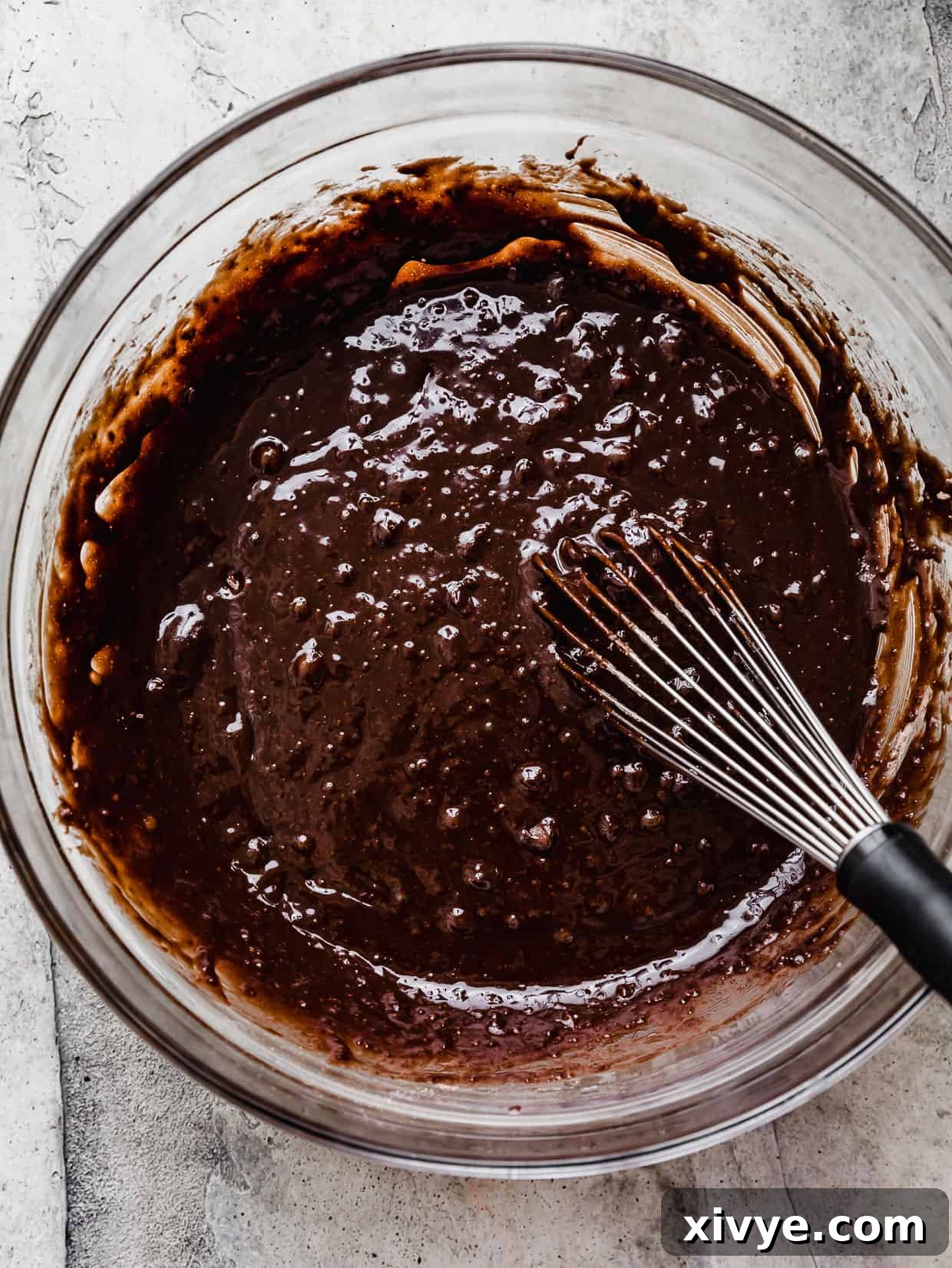 Cookies and Cream Fudge Brownies 5 A whisk mixing brownie batter in a glass bowl.