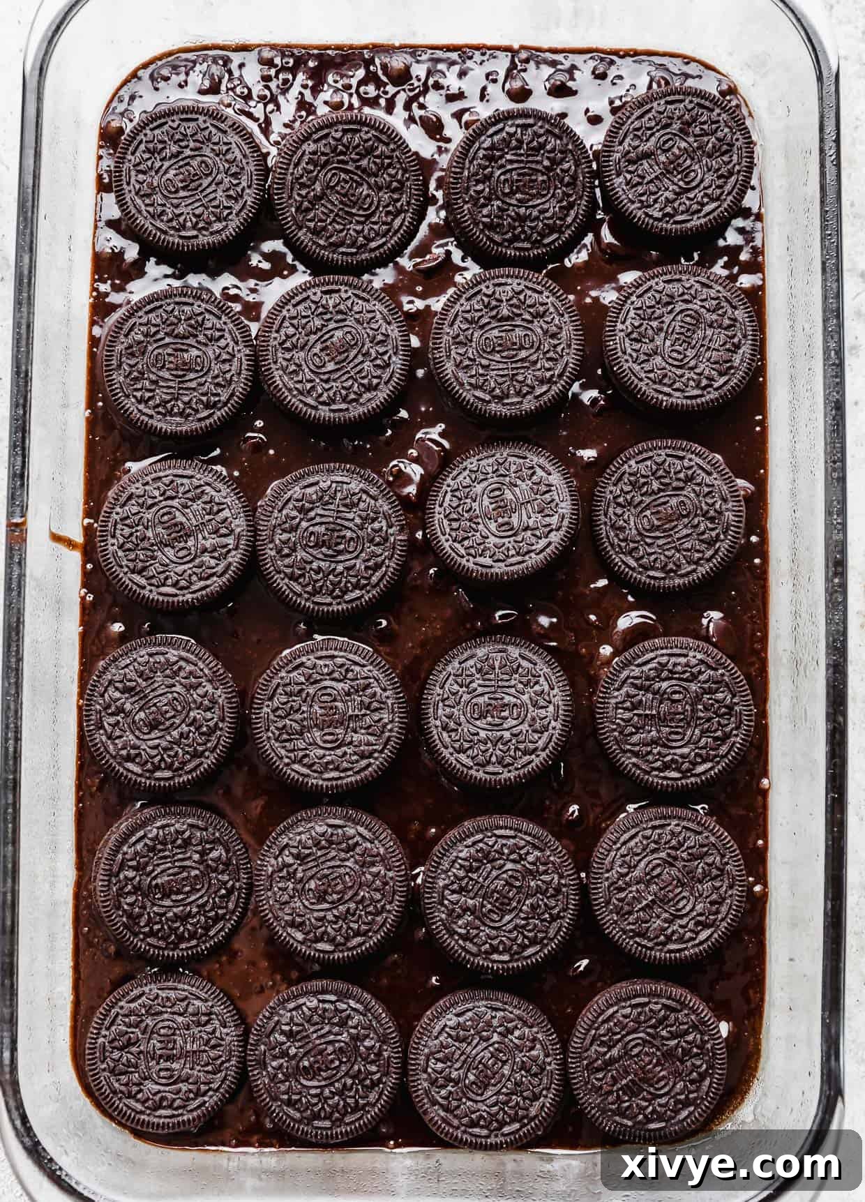 Cookies and Cream Fudge Brownies 7 Whole oreo cookies placed on top of brownie batter in a glass rectangular baking pan.