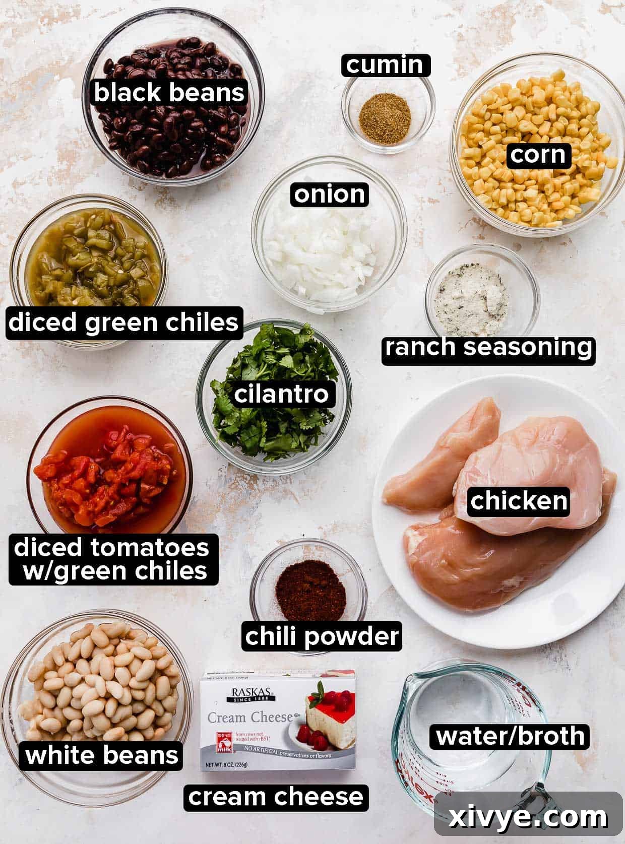 Crock Pot Cream Cheese Chicken Chili ingredients portioned into glass bowls on a white background, showcasing freshness.