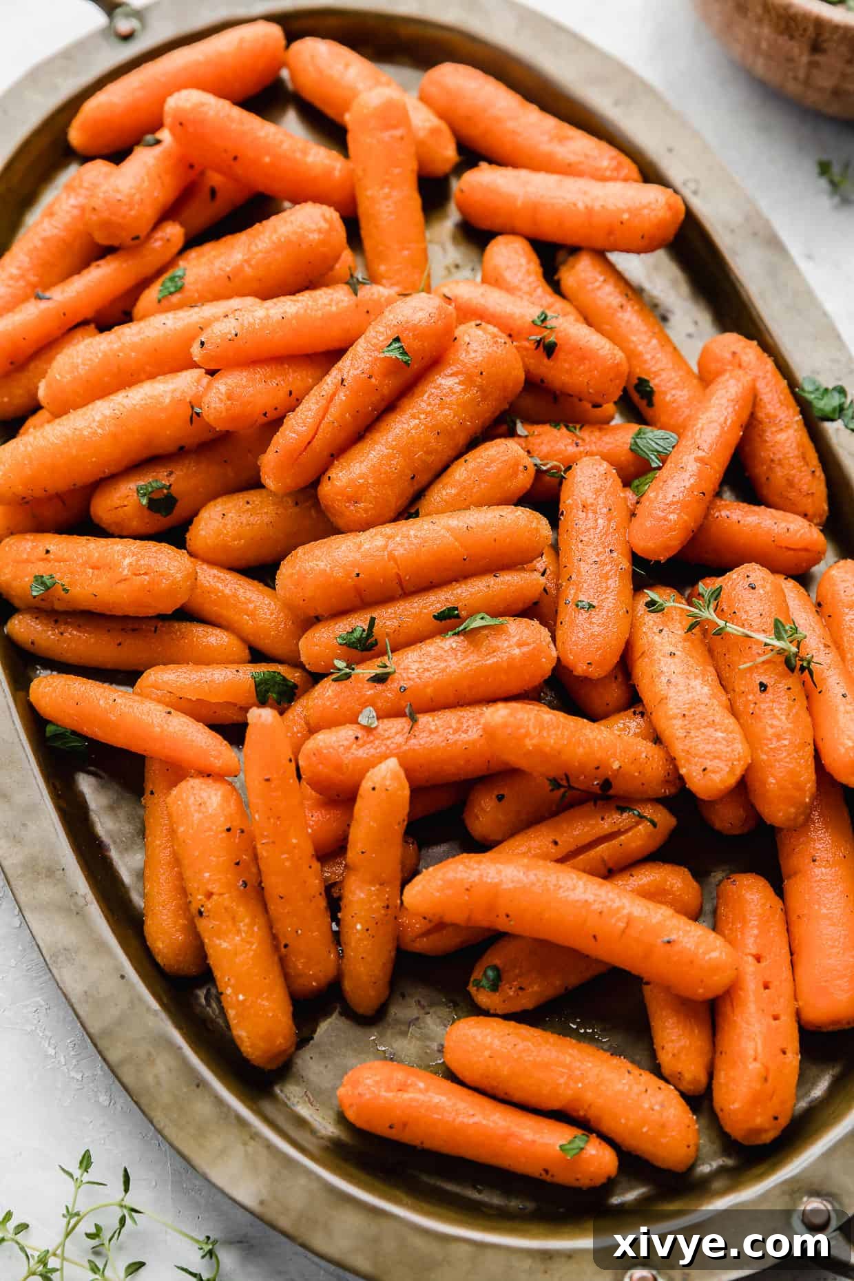A bronze oval plate with Roasted Baby Carrots on it.