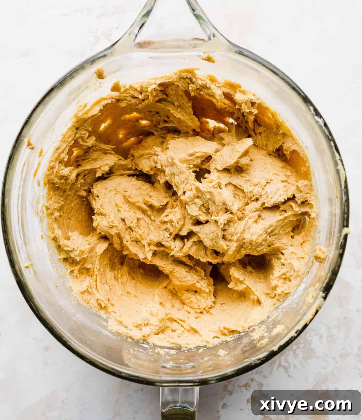 Pumpkin cookie batter in a glass bowl.