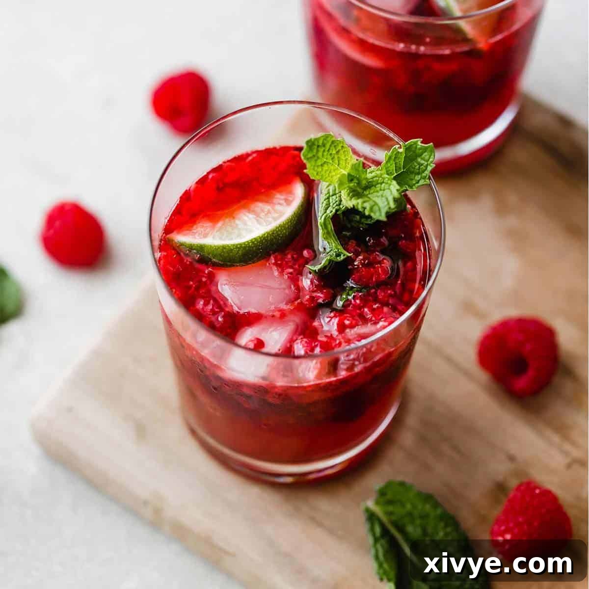Overhead photo of a homemade raspberry mocktail topped with lime and fresh mint sprig.