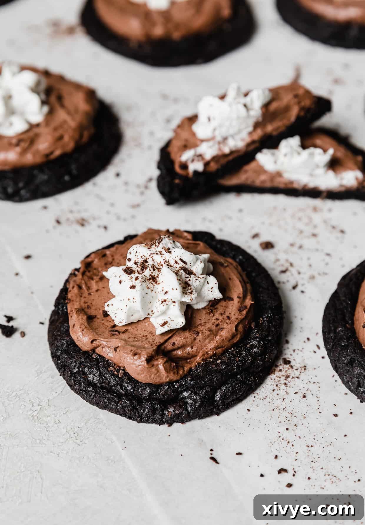 An oreo cookie base topped with a chocolate mousse and whipped topping to look like a French Silk Pie Cookie.